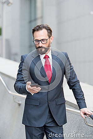 Calm man looking at the smartphone while reading messages Stock Photo