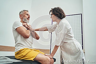 Focused osteopath assessing the patient physical fitness Stock Photo