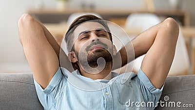 Calm peaceful man relaxing with closed eyes leaning back on sofa Stock Photo