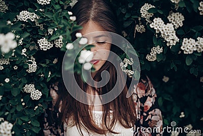 Calm portrait of beautiful hipster woman in blooming bush with w Stock Photo