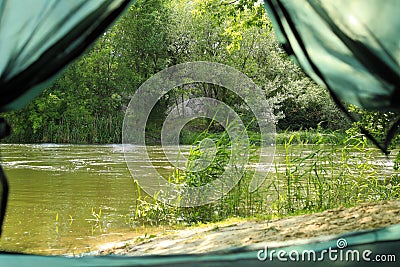 Calm river with forest on bank, view from tent Stock Photo