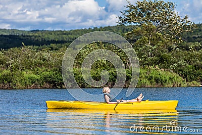 Calm River and Woman relaxing in a Kayak Stock Photo