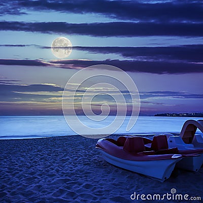 Calm sea beach with boats at night Stock Photo