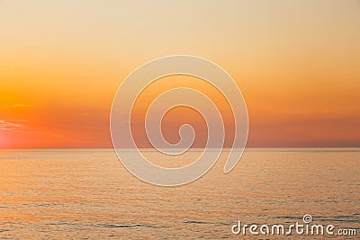 Calm Sea Or Ocean And Yellow Clear Sunset Or Sunrise Sky Background Stock Photo