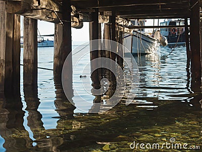 Calm sea water below old wooden pier at Agnontas beach, Skopelos island Stock Photo