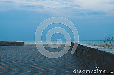 Calm seascape in dusk with nobody and rough cement border Stock Photo