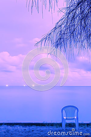 Calm seascape and empty chair at dusk Stock Photo