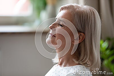 Calm serene middle aged woman breathing with eyes closed Stock Photo