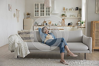 Calm sleepy middle aged woman resting on soft couch Stock Photo