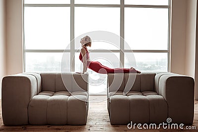 Flexible short-haired young woman stretching her body during yoga session Stock Photo