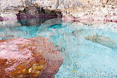 Calm turquoise colored water in pool in limestone cave on coast Stock Photo