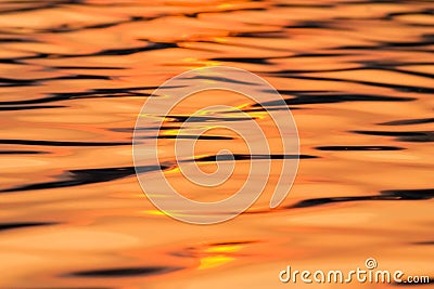 Calm water reflecting setting sun texture Stock Photo