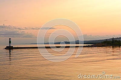 Calm Waters at Sunset on a Harbor Breakwater Stock Photo