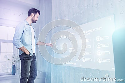 Young web developer touching a futuristic screen while working at home Stock Photo