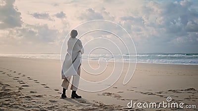 Calm woman contemplating ocean on empty quiet beach. Pensive model posing sea Stock Photo