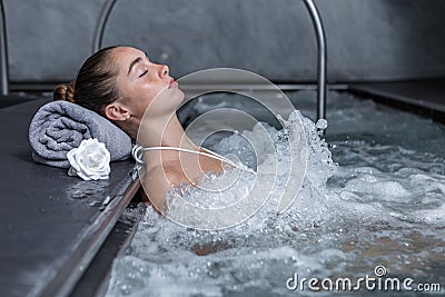 Calm woman resting in bubbling pool Stock Photo