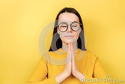 Calm young woman practicing yoga, breathing, mindful young female meditating with closed eyes, namaste gesture, healthy lifestyle Stock Photo