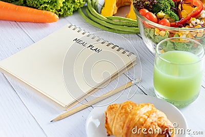 Calories control, meal plan, food diet and weight loss concept. meal plan writing on notebook planner with salad, fruit juice Stock Photo