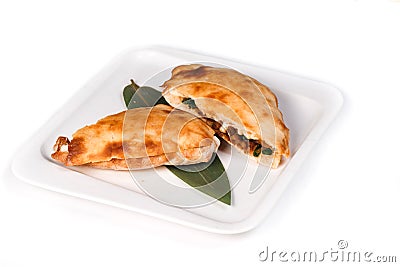 Calzone pizza halves on bamboo sheet in plate on isolated white background Stock Photo