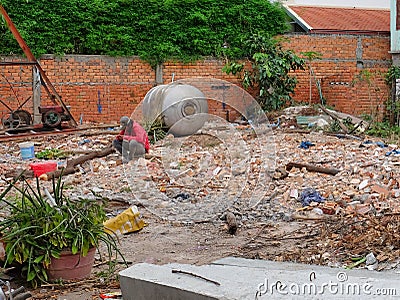 Man in a red shirt sitting on a pile of construction waste Editorial Stock Photo