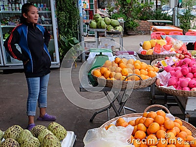 A young Asian girl sells fruit on a city street Editorial Stock Photo