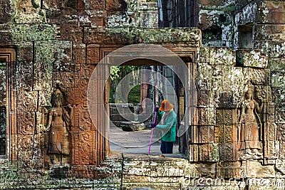 Cambodia. A woman cleans the old ruins of Banteay Kdei Temple Editorial Stock Photo