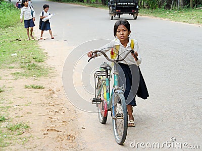 Cambodian little girl going to school by bicycle Editorial Stock Photo