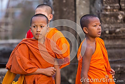 Cambodian monk kids in Angkor with orange traditional clothes Editorial Stock Photo