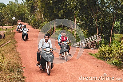 Cambodian people driving scooters through rural Cambodia Editorial Stock Photo