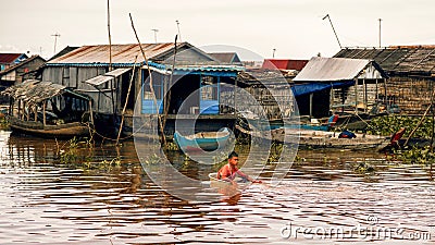 Cambodian people live on Tonle Sap Lake in Siem Reap, Cambodia. Cambodian boys use basin as a boat Editorial Stock Photo