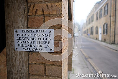 Cambridge UK December 2020 Sign prohibiting bicycles being parked in the area of Trinity Hall in cambridge, people leaving their Stock Photo