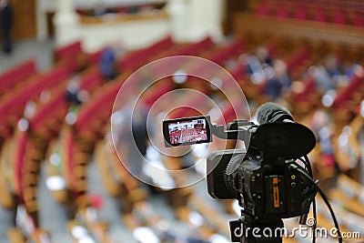 The camcorder stands on a tripod and removes the meeting room. Stock Photo