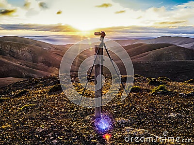 Camcorder on a tripod filming a sunset. Stock Photo