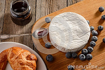 Camembert cheese, blueberries and jam served to a freshly baked croissant Stock Photo