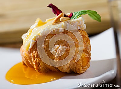 Camembert on croissant with honey Stock Photo