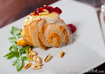 Camembert on mini croissant with jam, pine nuts Stock Photo