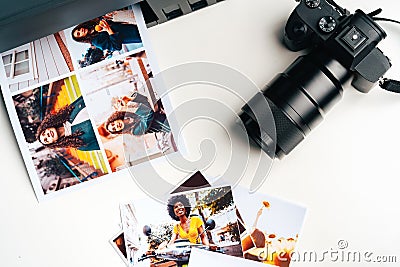 Camera and colorful printed photos of women on desk close up Stock Photo