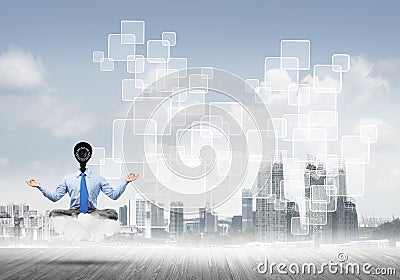 Camera headed man sitting in lotus pose on cloud against modern cityscape Stock Photo