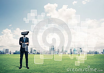 Camera headed man standing on green grass against modern cityscape Stock Photo