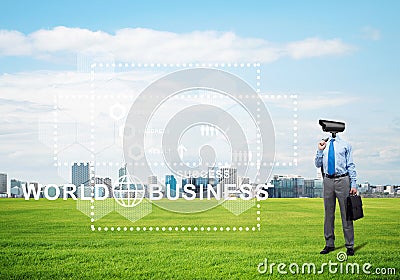 Camera headed man standing on green grass against modern cityscape Stock Photo