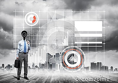 Camera headed man standing on wooden floor against modern cityscape Stock Photo