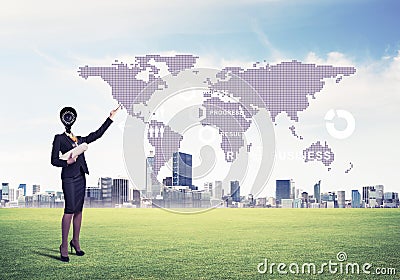 Camera headed woman standing on green grass against modern cityscape Stock Photo