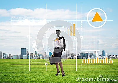 Camera headed woman standing on green grass against modern cityscape Stock Photo