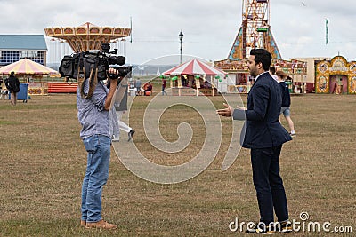 A camera man filming a news reporter Editorial Stock Photo