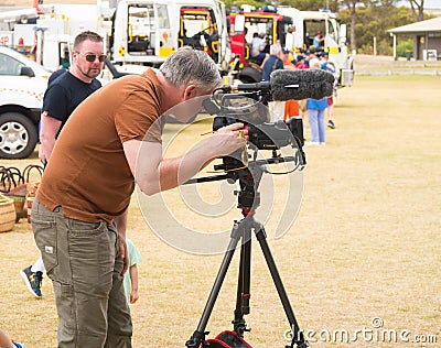 Camera operator records video with fire engines in view. Editorial Stock Photo