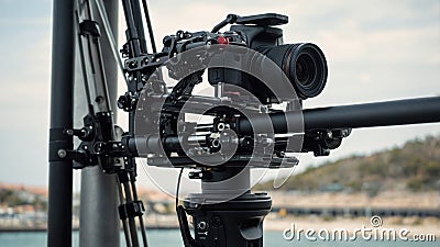 Camera setup on a stabilizing rig at a coastal location during a clear day with clouds Stock Photo