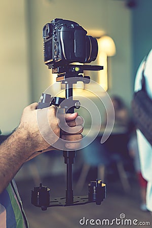 Camera on steadicam in male hands. videography, filmmaking, hobby and creativity concept. toned Stock Photo