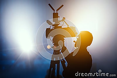 Cameraman silhouette on a live studio news stage.Professional cameraman with headphones in television news broadcast Stock Photo