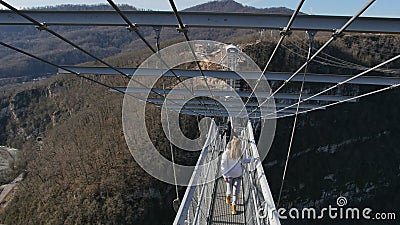 Caminhada da mulher através da ponte alta sobre a garganta em SkyPark Hackett AJ Sochi filme Caminhada da mulher através da ponte alta sobre a garganta em SkyPark Hackett AJ Sochi filme