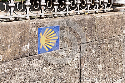 Camino de Santiago sign tile on stone wall. Way of St. James way shell Stock Photo